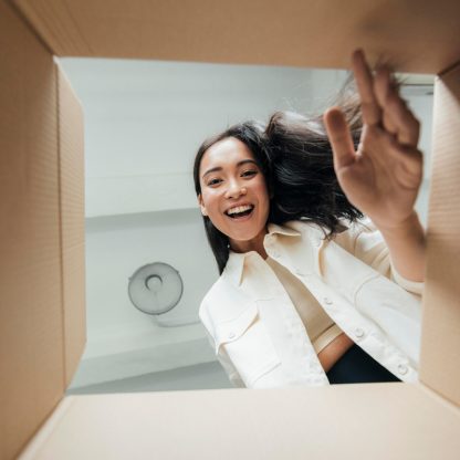 vista-inferior-mujer-sonriente-mirando-en-una-caja